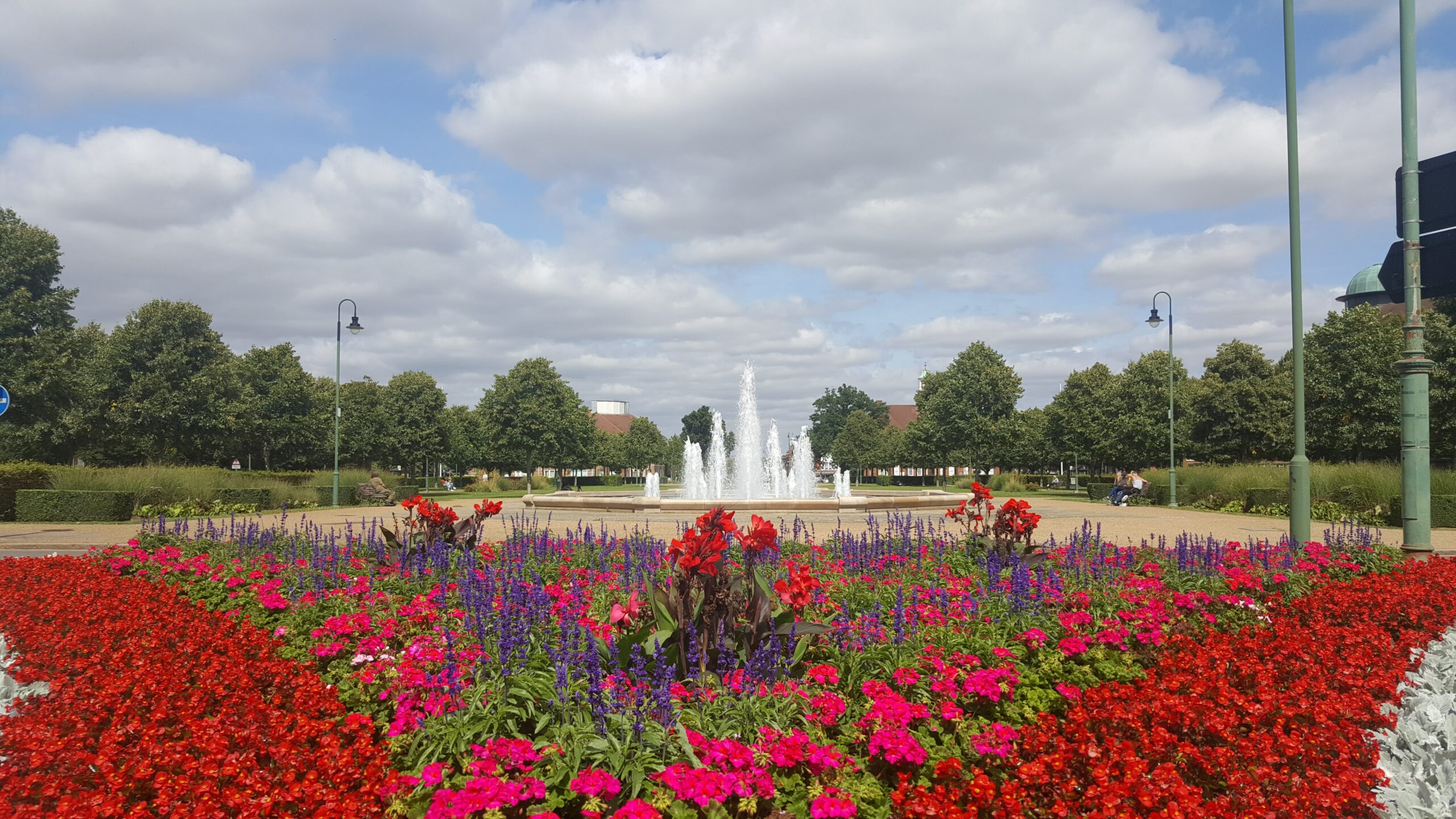 A fountain surrounded by red flowers in Letchworth.