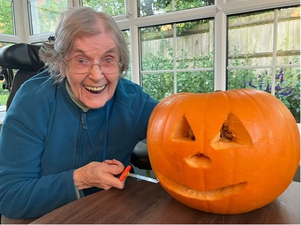 resident carving a pumpkin