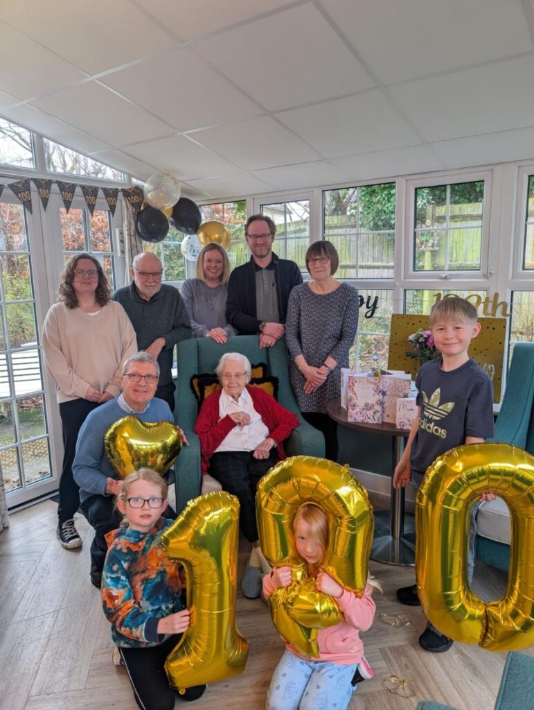 one of our residents on their 100th birthday surrounded by loved ones